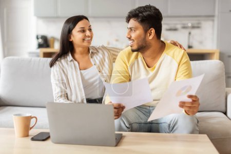 Photo for An eastern millennial couple casually engages in a discussion over paperwork with a laptop in the serene atmosphere of their home - Royalty Free Image