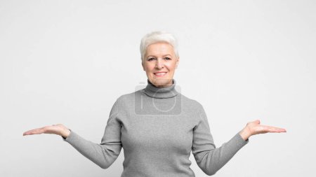Téléchargez les photos : Une femme européenne âgée montre un geste accueillant les mains ouvertes, illustrant le concept de choix au sein de s3niorlife - en image libre de droit