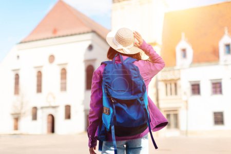 Touristin mit Strohhut blickt vor historischen Gebäuden auf eine Landkarte, die Entdeckungen und Reisen symbolisiert, Rückseite