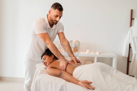 Foto de Foto representa a un masajista profesional que proporciona un tratamiento de spa a una dama negra, mostrando un ambiente de bienestar - Imagen libre de derechos