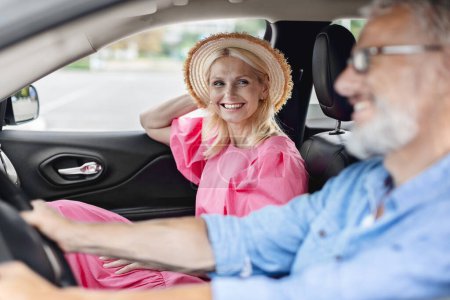 Téléchargez les photos : Inside the car view of a smiling, retired, elderly couple wearing casual clothes, after grocery shopping - en image libre de droit