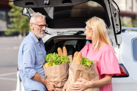 Un couple âgé partage un moment en voiture, avec des épiceries en main, mettant en valeur leur vie conjugale durable et leur compagnie