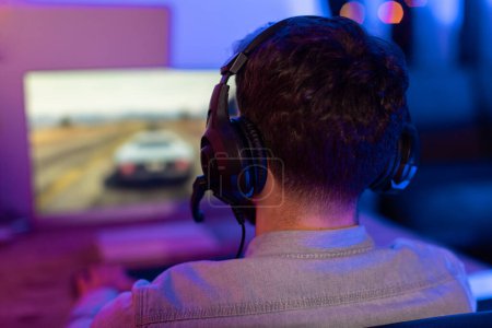 Photo for A dedicated millennial guy is absorbed in an intense gaming action, showing home gaming culture and possible addiction - Royalty Free Image