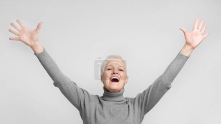 Senior european woman with mouth open and arms raised, a perfect s3niorlife visual for expressing excitement