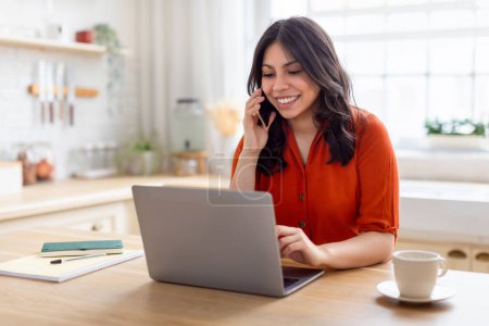 Téléchargez les photos : Femme attentive du Moyen-Orient sur un appel avec un ordinateur portable ouvert devant elle, peut-être discuter de questions liées au travail - en image libre de droit