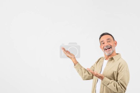 Un retraité souriant présente joyeusement un espace vide à ses côtés, isolé sur un fond blanc, invitant les téléspectateurs à imaginer ou à placer leur propre contenu, copier l'espace