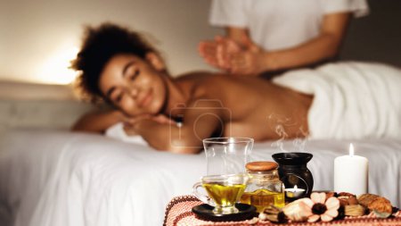 Téléchargez les photos : Spa d'arôme. Femme bénéficiant d'un massage dans un spa de luxe avec des bougies au premier plan - en image libre de droit