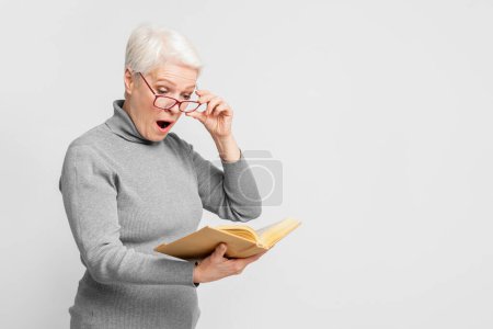 A focused elderly European woman deeply absorbed in reading a book, representing knowledge and lifelong learning in s3niorlife