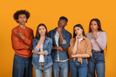 Fünf junge multiethnische Erwachsene mit nachdenklichen Mienen, die zusammenstehen, Handgesten, die auf Nachdenken oder Entscheidungsfindung hindeuten