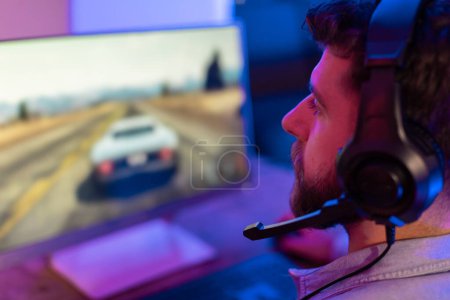 Photo for A young millennial guy showcases his colorful and vibrant gaming setup at home, highlighting gaming culture and addiction - Royalty Free Image