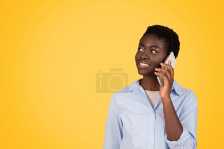 Engagée dans la communication, cette femme afro-américaine de génération z utilise un smartphone, signifiant l'importance de la connectivité, isolé, espace de copie