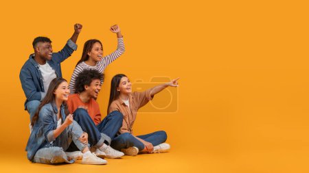 Multiethnic friends excitedly cheering and pointing to the side, exemplifying celebration and happiness in a diverse group, isolated on a yellow background, copy space
