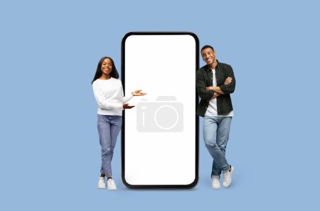 African American woman presents while the man observes a blank smartphone screen mockup copy space on blue