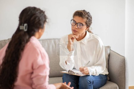 Psicoterapeuta joven de apoyo escuchando a la señora cliente compartir su historia, pensamientos. Concepto de trastornos de salud mental