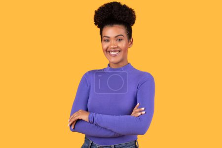 Photo for Hispanic woman standing with her arms crossed, smiling warmly. She exudes confidence and contentment as she gazes directly at the camera. - Royalty Free Image
