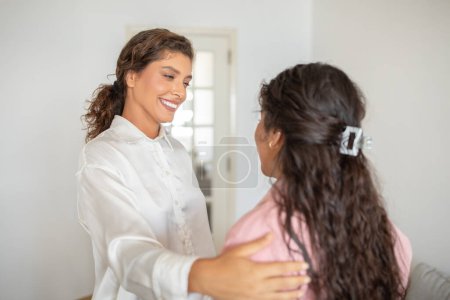 Beautiful smiling woman greeting client at her office, friendly therapist touching lady shoulder, have conversation