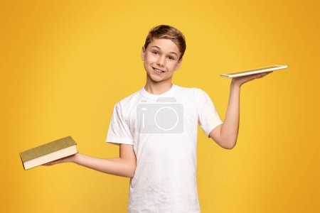 A young boy standing, holding a book in one hand and a tray in the other.