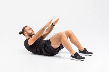 Téléchargez les photos : Un homme s'engage activement dans un exercice croquant sur le sol, travaillant ses muscles abdominaux tout en maintenant une forme appropriée sur fond blanc - en image libre de droit