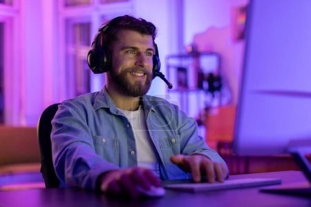 Photo for A millennial guy dons a gaming headset at home, his calm expression conveying the serene addiction of gaming in a personalized space - Royalty Free Image