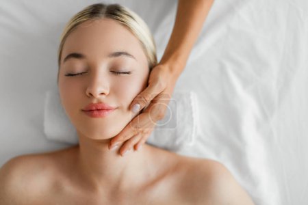 Photo for A blissful young woman is receiving a soothing neck massage from a therapists skilled hands, evoking a sense of tranquility and wellness, copy space, top view - Royalty Free Image