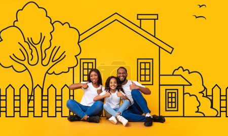 Famille afro-américaine père mère assis avec une fille enfant contre un mur avec une maison dessinée. Concept hypothécaire