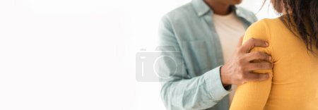 Primer plano de una mano de hombre negro que proporciona comodidad a una mujer con un toque suave, amplio espacio de copia a la izquierda para el uso de banner web