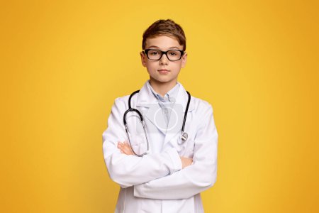 Photo for Handsome teenage doctor posing with arms crossed, orange panorama background with free space - Royalty Free Image