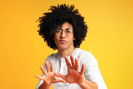 Photo for Cute black man waving hands like magician , looking mysteriously at camera, orange background - Royalty Free Image