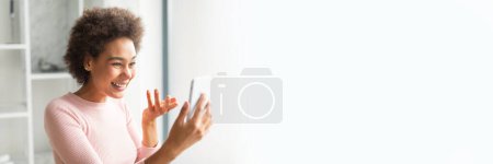 Fröhliche afrikanisch-amerikanische Frau beim Umgang mit einem Tablet vor weißem Hintergrund mit viel Kopierplatz für ein Web-Banner