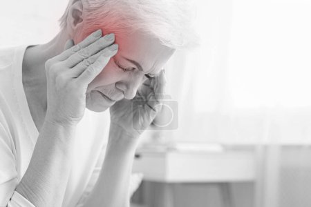 Photo for Senior woman having headache and touching her temples, suffering from migraine, free space - Royalty Free Image