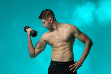 Ein Mann ohne Hemd hält eine Hantel in einem Fitnessstudio. Er wirkt fokussiert und bemüht in seiner Trainingsroutine, zeigt Stärke und Entschlossenheit.