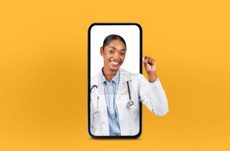 Junge schwarze Ärztin erscheint in einem Smartphone für Online-Konsultationen, veranschaulicht moderne Medizin und zeigt Medikamentenpille