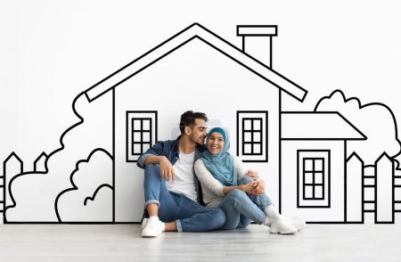 Photo for Loving millennial muslim couple planning their dream home against a hand-drawn house sketch on white wall background. Mortgage concept - Royalty Free Image