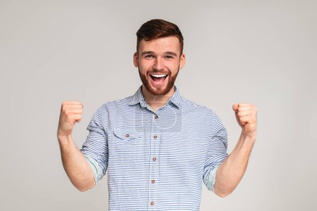 Photo for Cheerful guy showing his biceps and smiling on studio background, panorama, copy space - Royalty Free Image