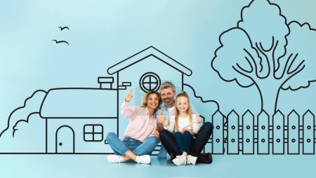 Happy european family father mother sitting with a child daughter against a wall with a drawn house, showing thumb ups. Mortgage concept