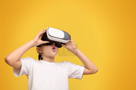 Photo for A young child in awe while using a VR headset. - Royalty Free Image