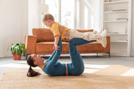 A joyful moment is captured as a mother, lying on her back, lifts her young child with her feet, creating a fun and engaging playtime, exercising with her son at home