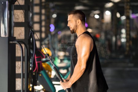 Ein Mann im Tanktop lässt seine Muskeln spielen, insbesondere seinen Bizeps, und demonstriert Kraft und Fitness. Seine Arme werden nach oben gepumpt, und die Muskeln prallen sichtbar ab..