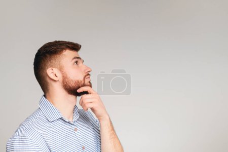 Photo for Portrait of thoughtful guy on beige background, panorama, copy space - Royalty Free Image