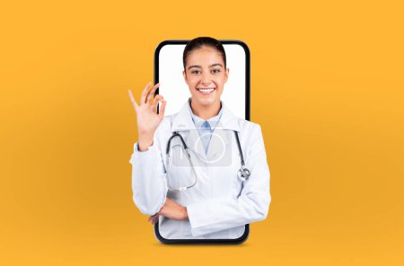 Depicting digital health technology, a young woman stands as a doctor within a smartphone, embodying the future of telehealth, showing okay gesture