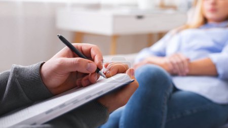 Foto de Psicoterapeuta profesional tomando notas, escuchando los problemas del paciente femenino, panorama - Imagen libre de derechos