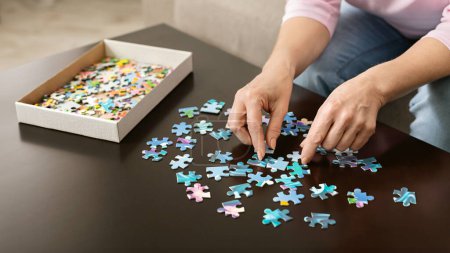 Photo for Retirement entertainment. Senior woman playing jigsaw puzzle at home, empty space - Royalty Free Image