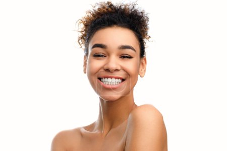 Foto de Una fotografía de cerca de una joven afroamericana con una sonrisa radiante, exudando calidez, confianza y felicidad, aislada sobre un fondo blanco - Imagen libre de derechos