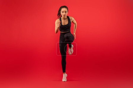 Eine Frau mit schwarzem Sport-BH-Top und Leggings ist beim Training zu sehen. Sie ist körperlich aktiv und demonstriert Fitness und Stärke in ihrem Workout-Outfit.