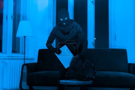 Ein Einbrecher scheint Laptop zu stehlen, durchwühlt nachts einen Rucksack in einer Wohnung und schafft eine verstörende Atmosphäre