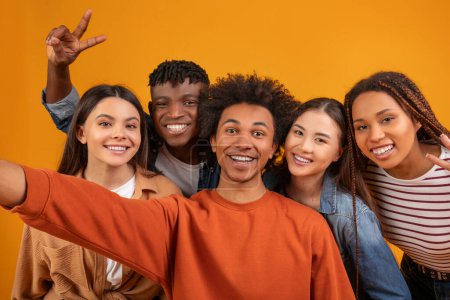 Foto de Un equipo multiétnico dinámico comparte un momento alegre, tomando un selfie juguetón con amigos, destacando la diversidad y la amistad - Imagen libre de derechos