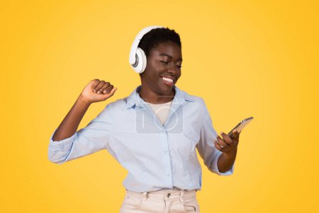 Photo for A vibrant image of an african american woman, likely a zoomer, enjoying music through headphones, showcasing the joy of rhythm, isolated - Royalty Free Image