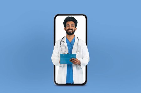 Un joven profesional médico hindú se muestra en una aplicación de telemedicina dentro de un teléfono inteligente, posicionado en un entorno profesional pero accesible