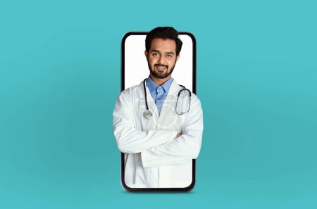 Un joven profesional médico indio se muestra en una aplicación de telemedicina dentro de un teléfono inteligente, posicionado en un entorno profesional pero accesible