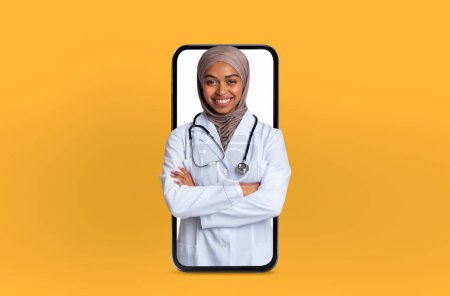 Cette image montre une jeune femme afro-américaine en hijab doctor sur un écran de smartphone, fournissant des services de télésanté innovants à partir d'un bureau soigné et professionnel.